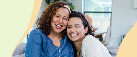 Smiling mother embraces daughter